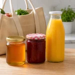 pots de miel et confiture avec bouteille de jus sur un plan de travail après les courses