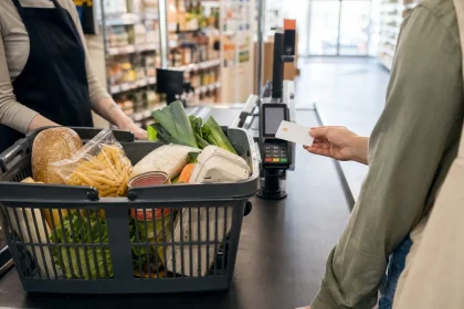 Panier de courses alimentaires posé sur un tapis de caisse avec carte titre restaurant